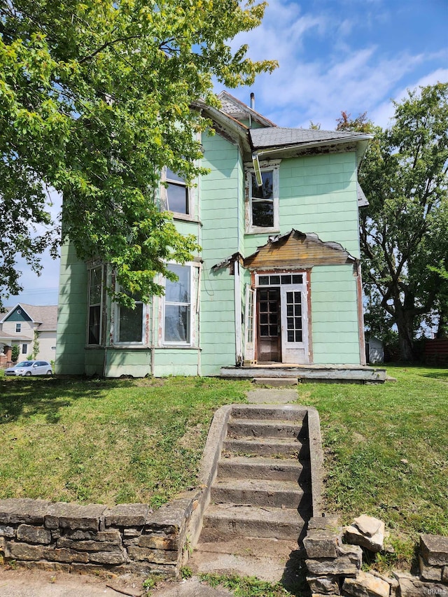 rear view of house featuring a yard