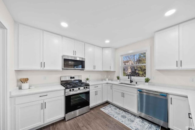1114 Beacon Dr, Mishawaka, IN 46544 - kitchen featuring a sink, dark wood-style floors, white cabinets, and stainless steel appliances
