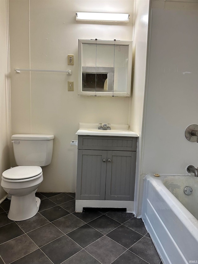 bathroom with toilet, vanity, and tile flooring