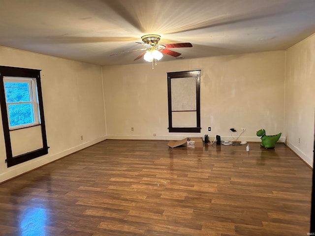 empty room with ceiling fan and dark wood-type flooring