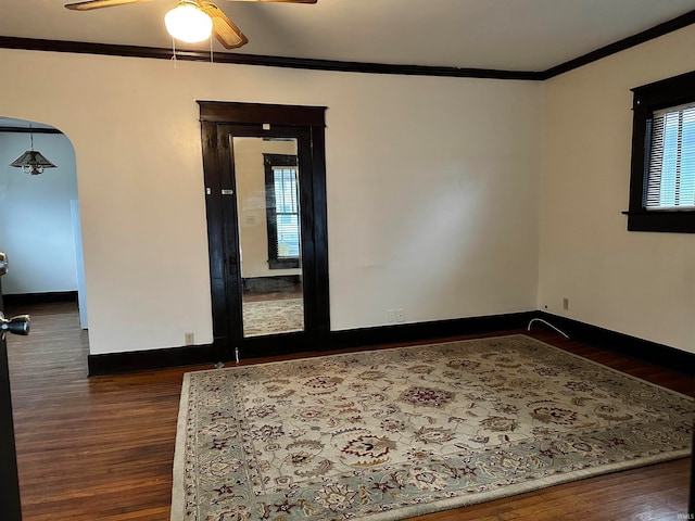 spare room featuring dark hardwood / wood-style flooring, ceiling fan, and crown molding