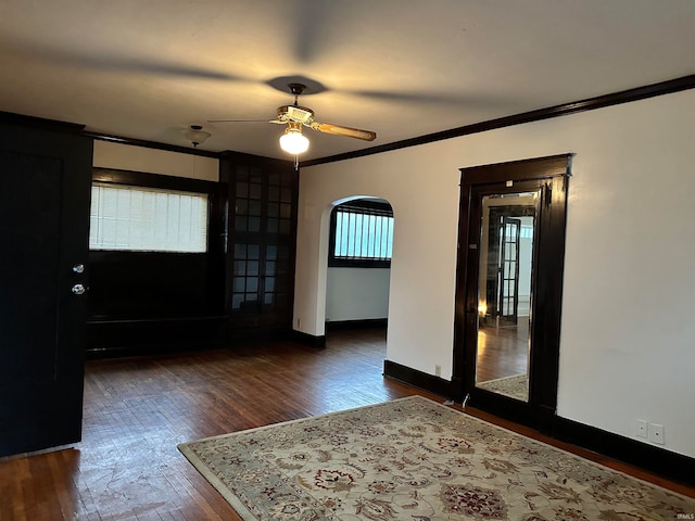 unfurnished room with crown molding, ceiling fan, and dark hardwood / wood-style flooring