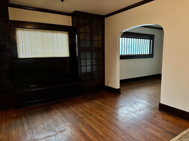 unfurnished room with crown molding and dark wood-type flooring