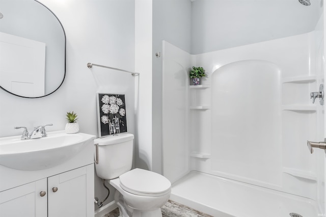 bathroom featuring vanity, toilet, and walk in shower