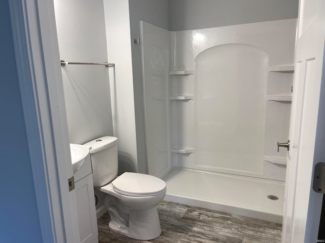 bathroom featuring vanity, toilet, wood-type flooring, and walk in shower