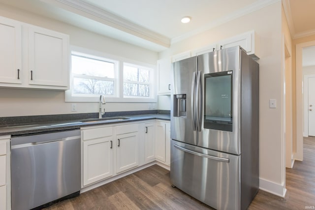 kitchen featuring stainless steel appliances, ornamental molding, sink, and white cabinets