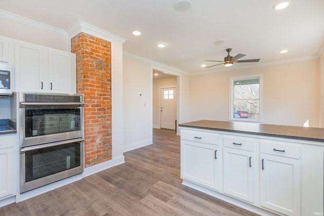 kitchen featuring white cabinetry, a wealth of natural light, and stainless steel double oven