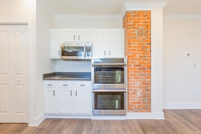 kitchen featuring stainless steel appliances, white cabinetry, and light wood-type flooring