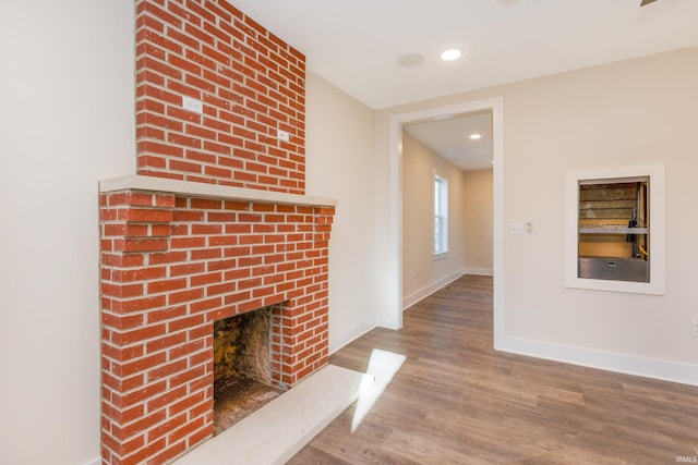 unfurnished living room featuring a fireplace and wood-type flooring