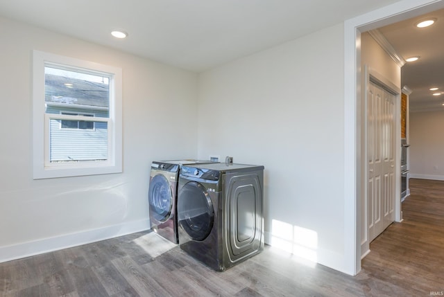 laundry room featuring crown molding, separate washer and dryer, and hardwood / wood-style floors