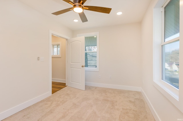 carpeted spare room featuring ceiling fan