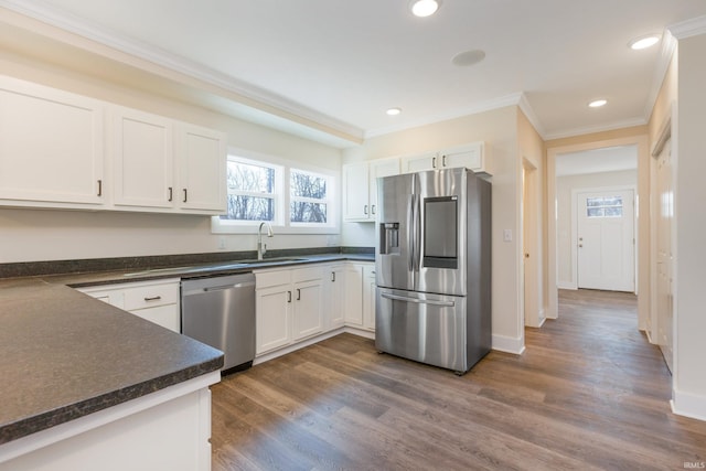 kitchen with sink, ornamental molding, appliances with stainless steel finishes, dark hardwood / wood-style flooring, and white cabinets