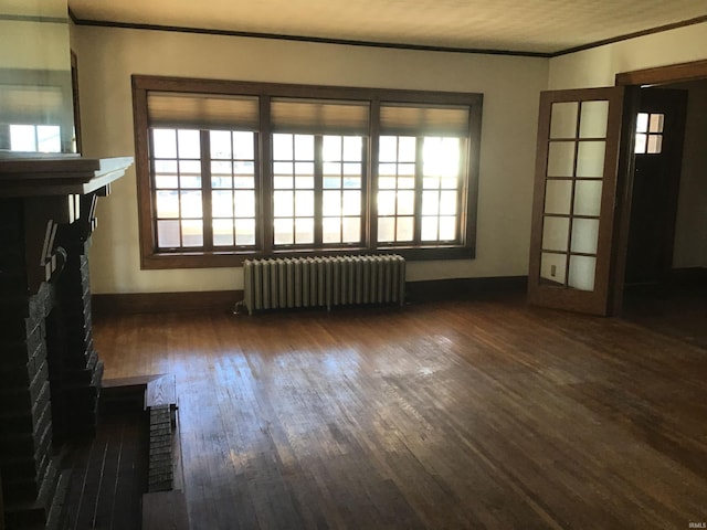 unfurnished living room with a fireplace, plenty of natural light, and radiator