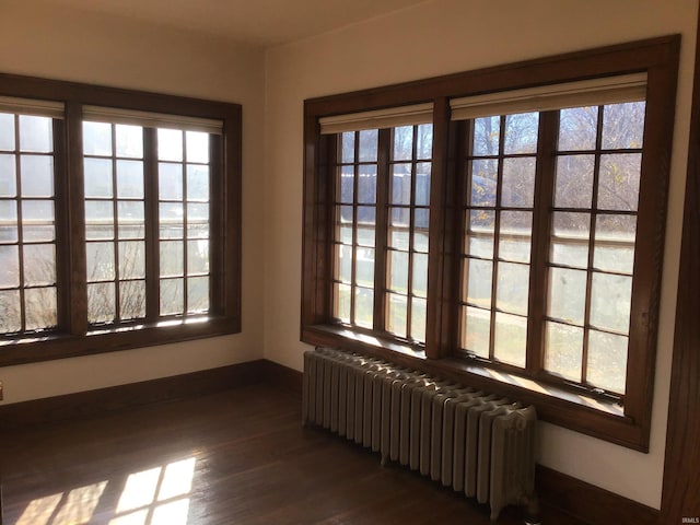 unfurnished sunroom featuring radiator and plenty of natural light