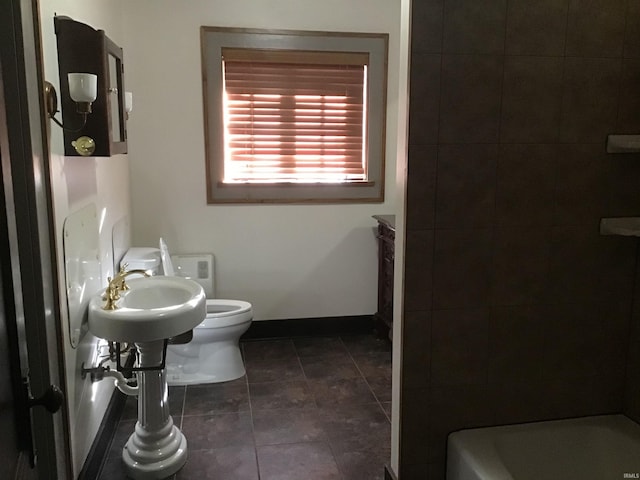 bathroom featuring tile patterned floors, toilet, and a bathtub