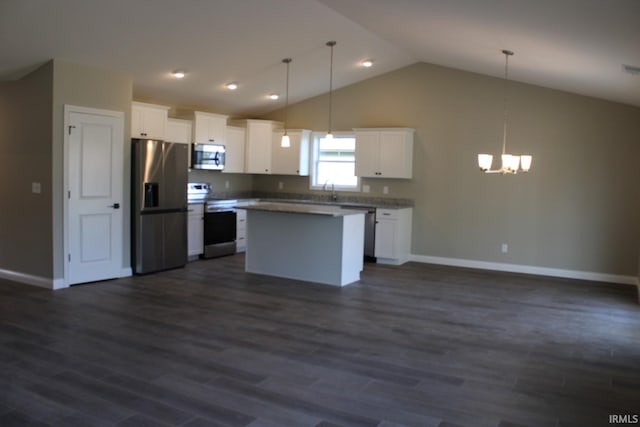 kitchen featuring white cabinets, stainless steel appliances, decorative light fixtures, and dark hardwood / wood-style flooring