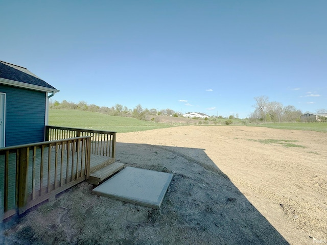 view of yard with a deck and a rural view