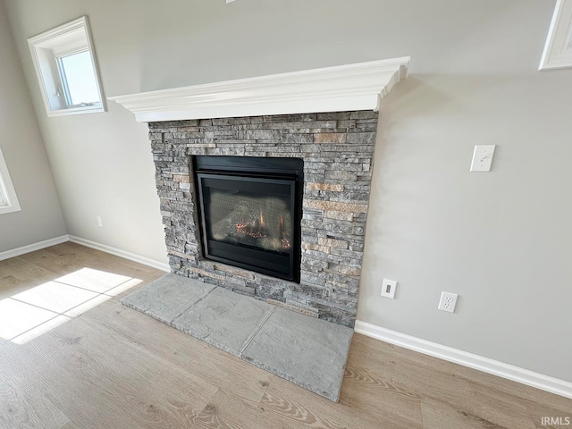 room details featuring hardwood / wood-style flooring and a stone fireplace