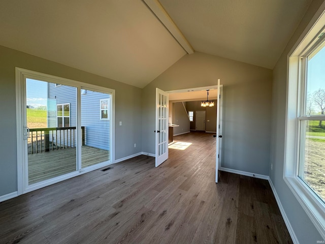 empty room featuring an inviting chandelier, vaulted ceiling with beams, and hardwood / wood-style flooring