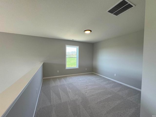 carpeted spare room featuring a textured ceiling