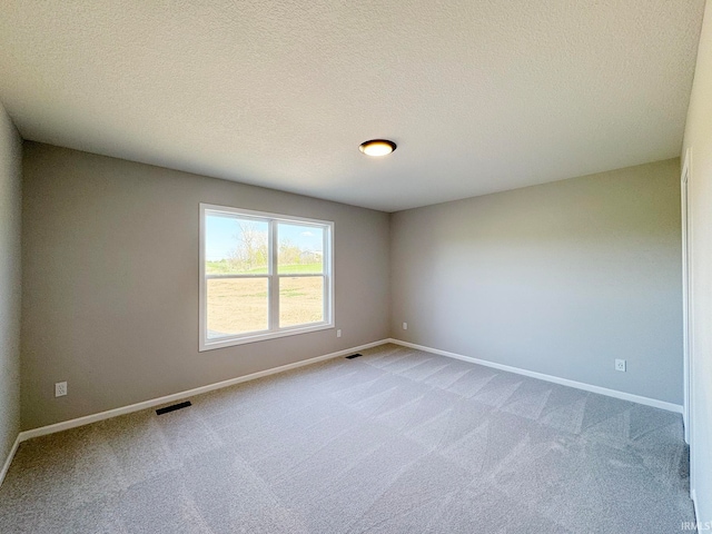 carpeted spare room featuring a textured ceiling