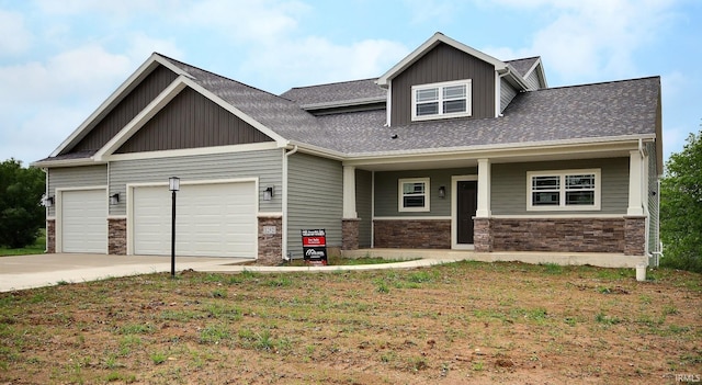 craftsman inspired home with covered porch, a front lawn, and a garage