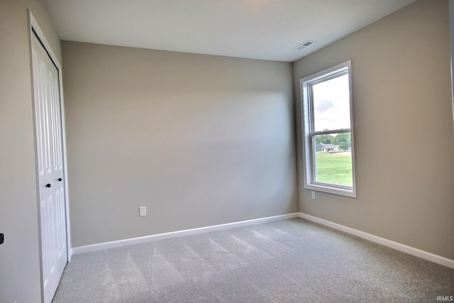 unfurnished bedroom with light carpet and a closet