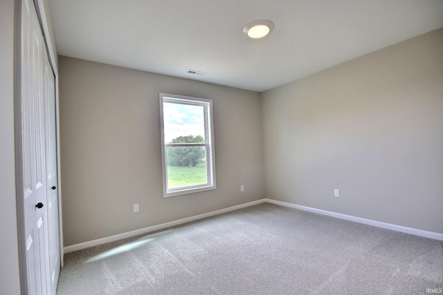 unfurnished room featuring light colored carpet