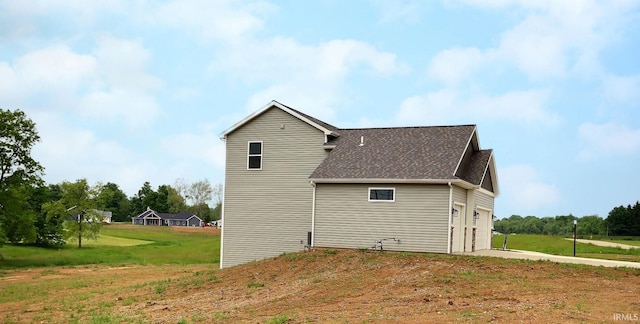 1282 Stintson Dr, Huntington, IN 46750 - view of side of home with a lawn, driveway, roof with shingles, and an attached garage