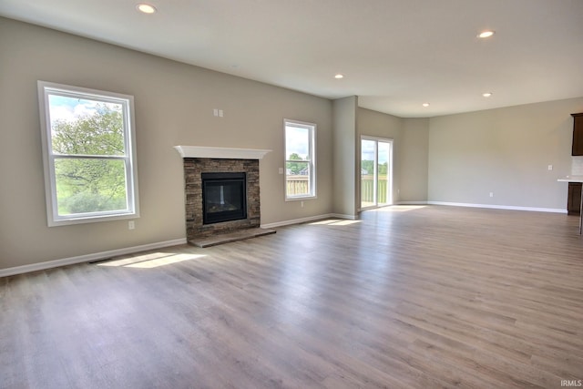 unfurnished living room featuring light wood-type flooring and a fireplace