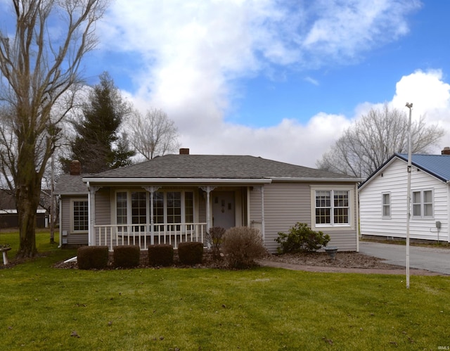 ranch-style house featuring a front yard and covered porch