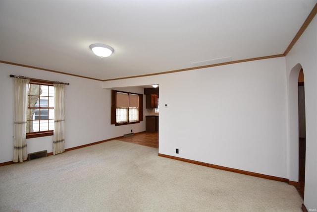 carpeted spare room with crown molding and a healthy amount of sunlight