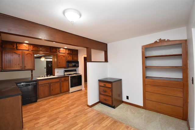 kitchen featuring light wood-type flooring, sink, and black appliances