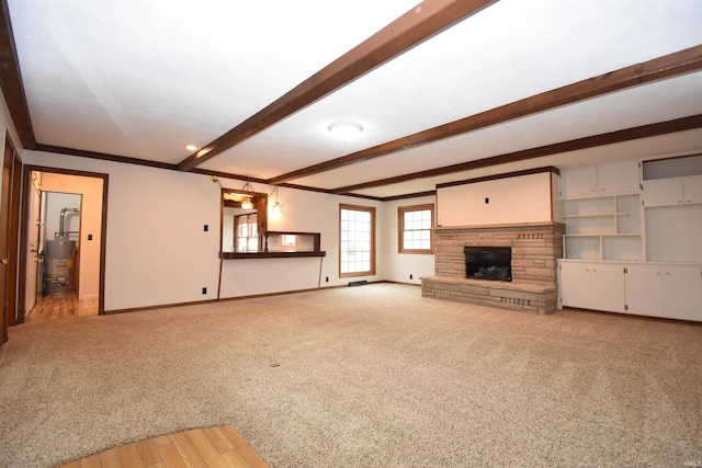 unfurnished living room featuring gas water heater, a fireplace, beamed ceiling, and light hardwood / wood-style flooring