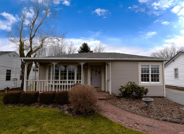 single story home with a front lawn and covered porch