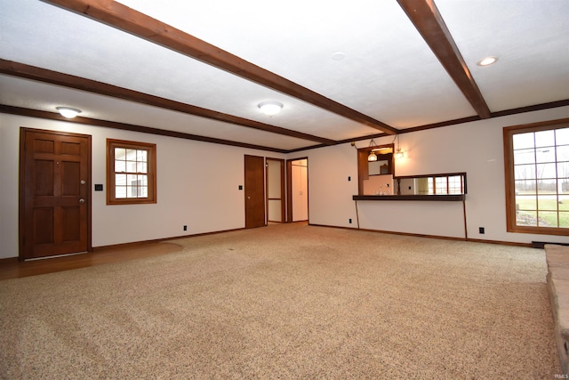 unfurnished living room featuring beam ceiling and carpet