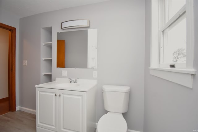 bathroom with wood-type flooring, vanity, and toilet