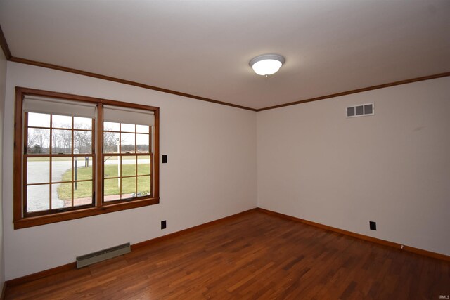 empty room with ornamental molding and dark hardwood / wood-style floors