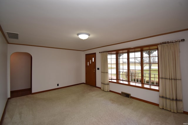 carpeted empty room featuring crown molding