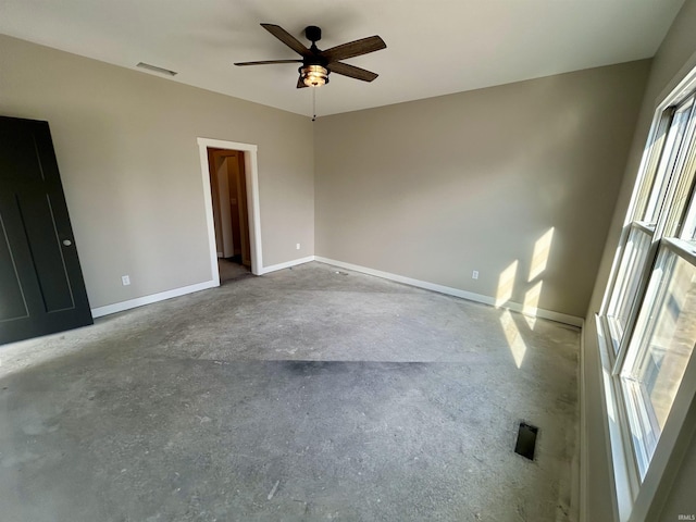 spare room with ceiling fan and concrete floors