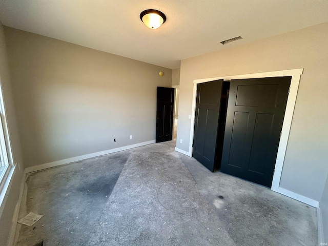 unfurnished bedroom featuring a closet and concrete floors