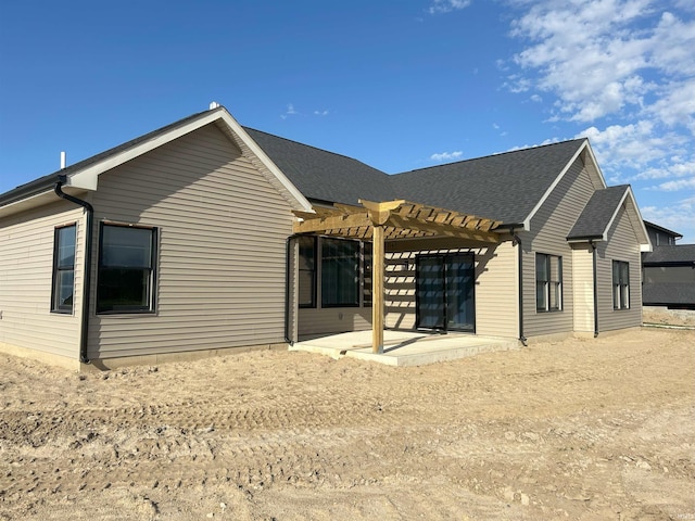 back of property with a pergola and a patio area