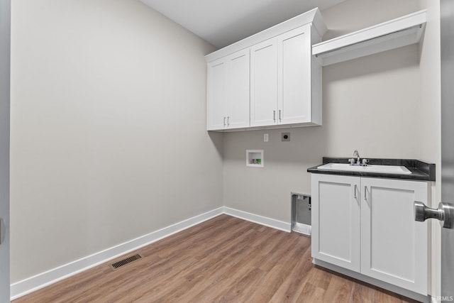 washroom with sink, cabinets, light hardwood / wood-style flooring, hookup for a washing machine, and electric dryer hookup