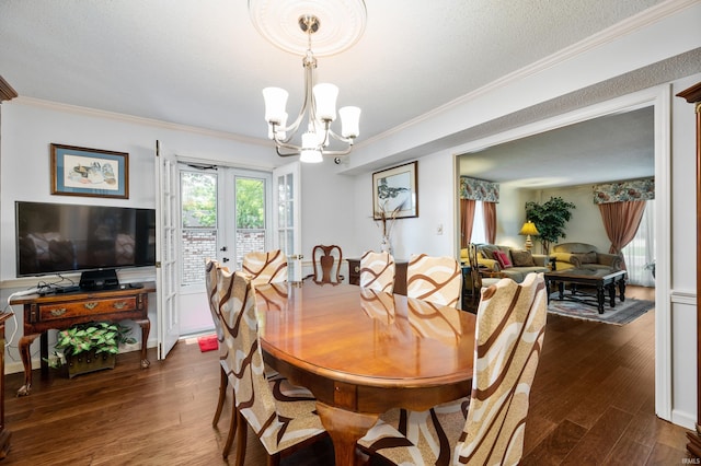 dining space featuring french doors, dark hardwood / wood-style flooring, a textured ceiling, crown molding, and a chandelier