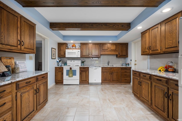 kitchen featuring light stone countertops, beam ceiling, and white appliances