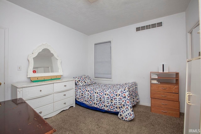 bedroom featuring a textured ceiling and dark colored carpet