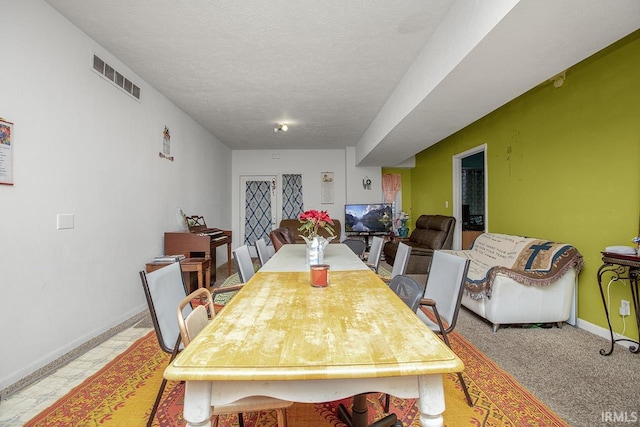 dining area with a textured ceiling and light tile floors