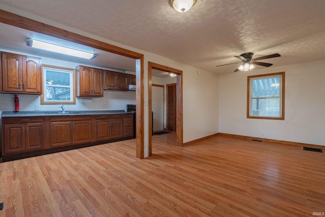 kitchen with sink, ceiling fan, and light hardwood / wood-style flooring