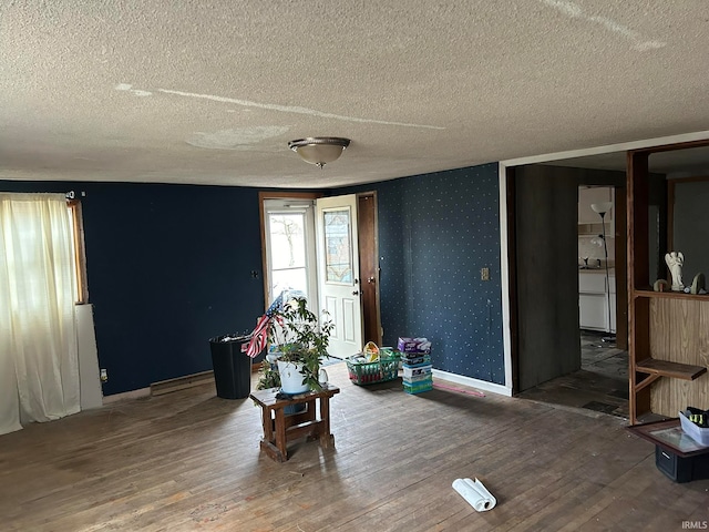 living area with a textured ceiling and dark hardwood / wood-style floors