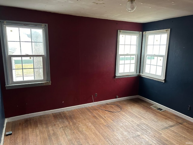 unfurnished room featuring plenty of natural light and hardwood / wood-style floors